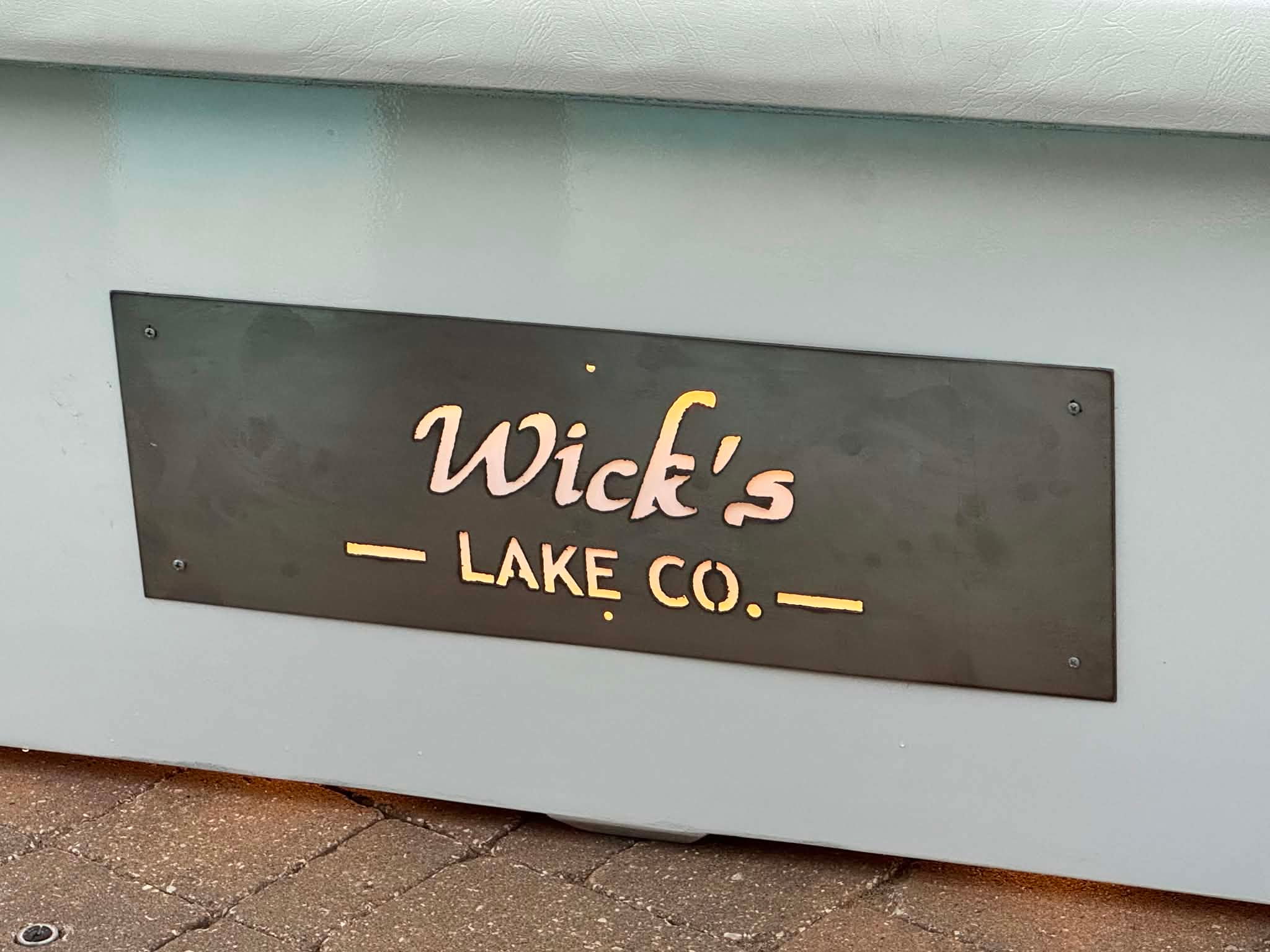 Close-up of the backlit Wick's Lake Co plaque on The Admiral